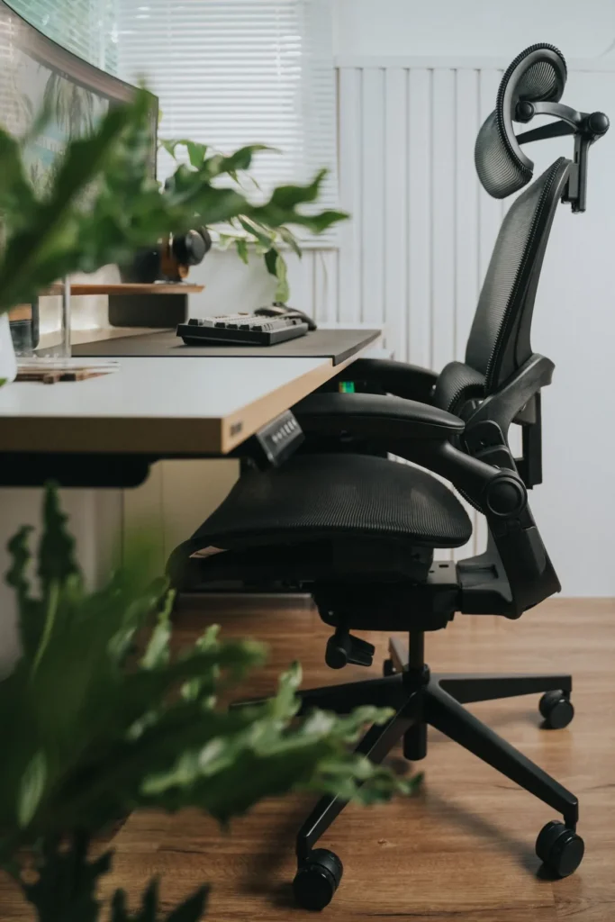Side view of an ergonomic mesh office chair with a contoured backrest at a home desk