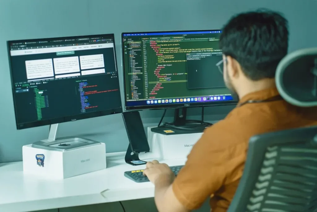 Person with good posture working at a dual monitor setup with screens at eye level