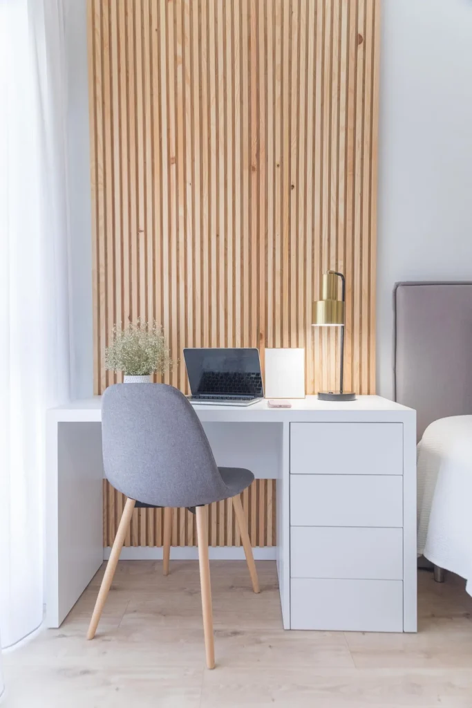 Small bedroom with a compact white desk tucked into a bright corner by the window